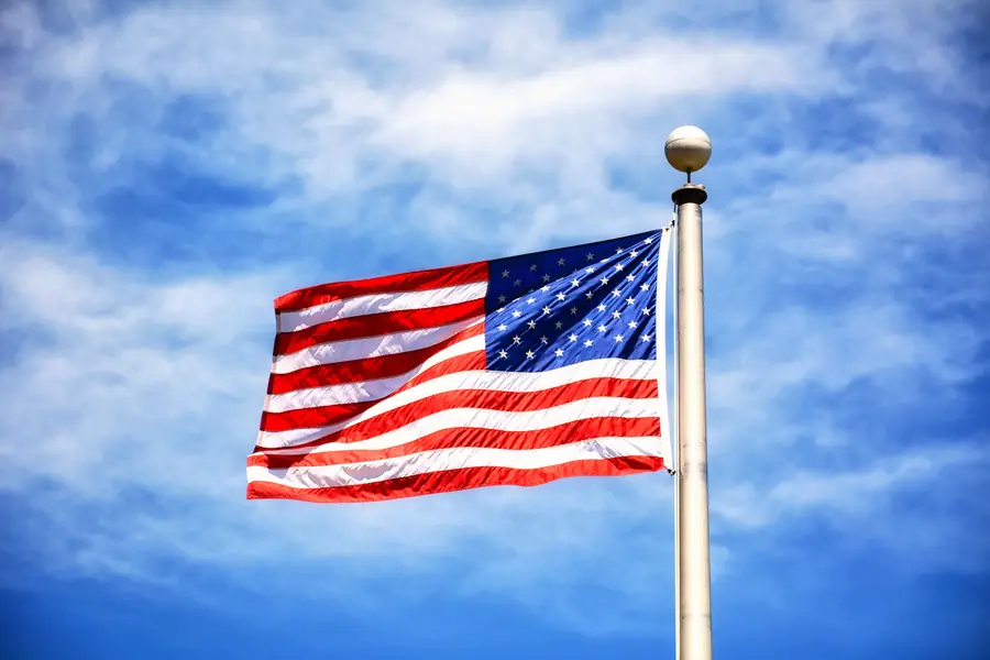 An American flag against a cloudy sky